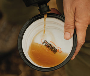 Furvor bone broth pouring from a squeeze bottle into a collapsible travel bowl held in hand